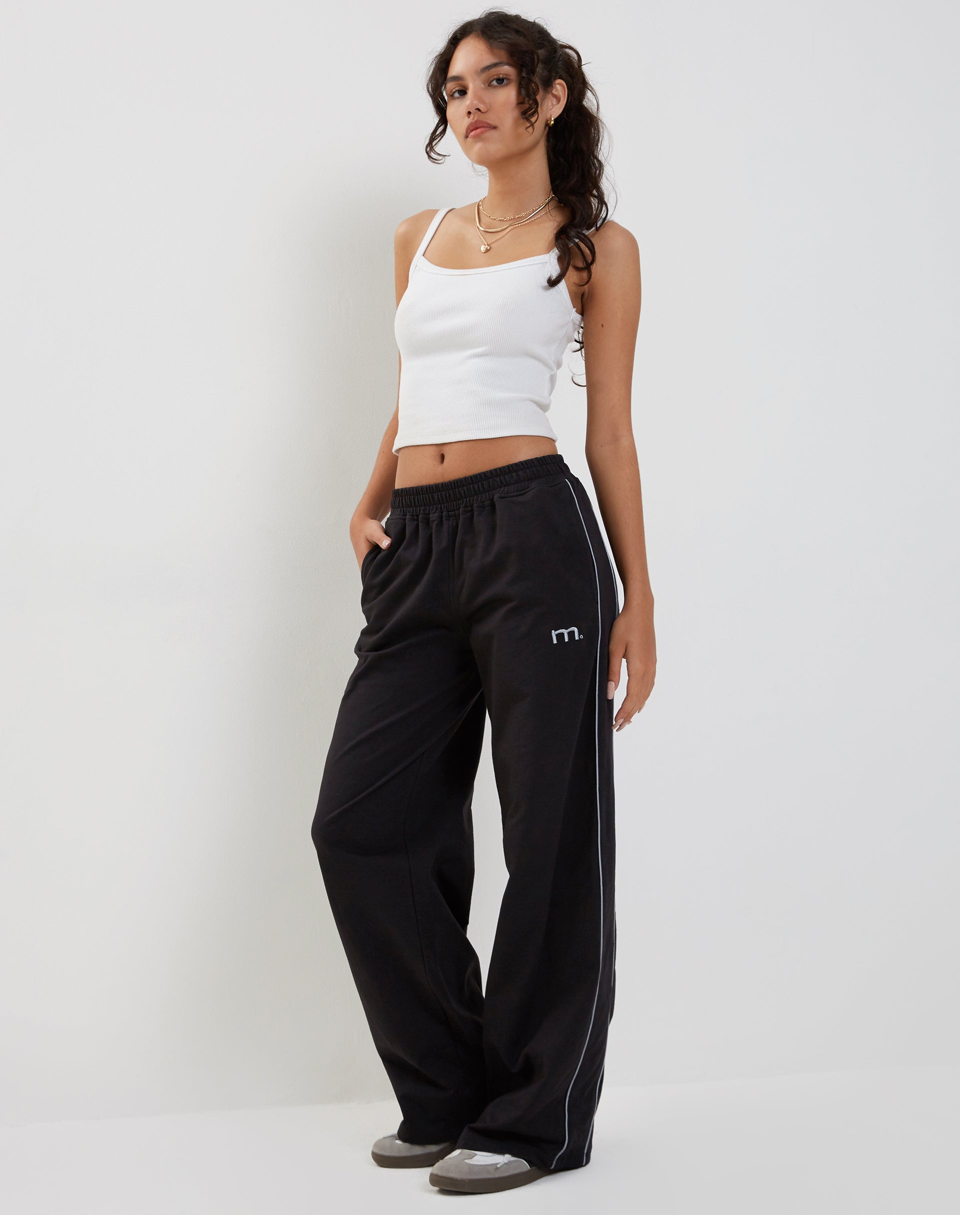 Imagen de Benton Wide Leg Jogger en negro con ribete gris oscuro y bordado "M