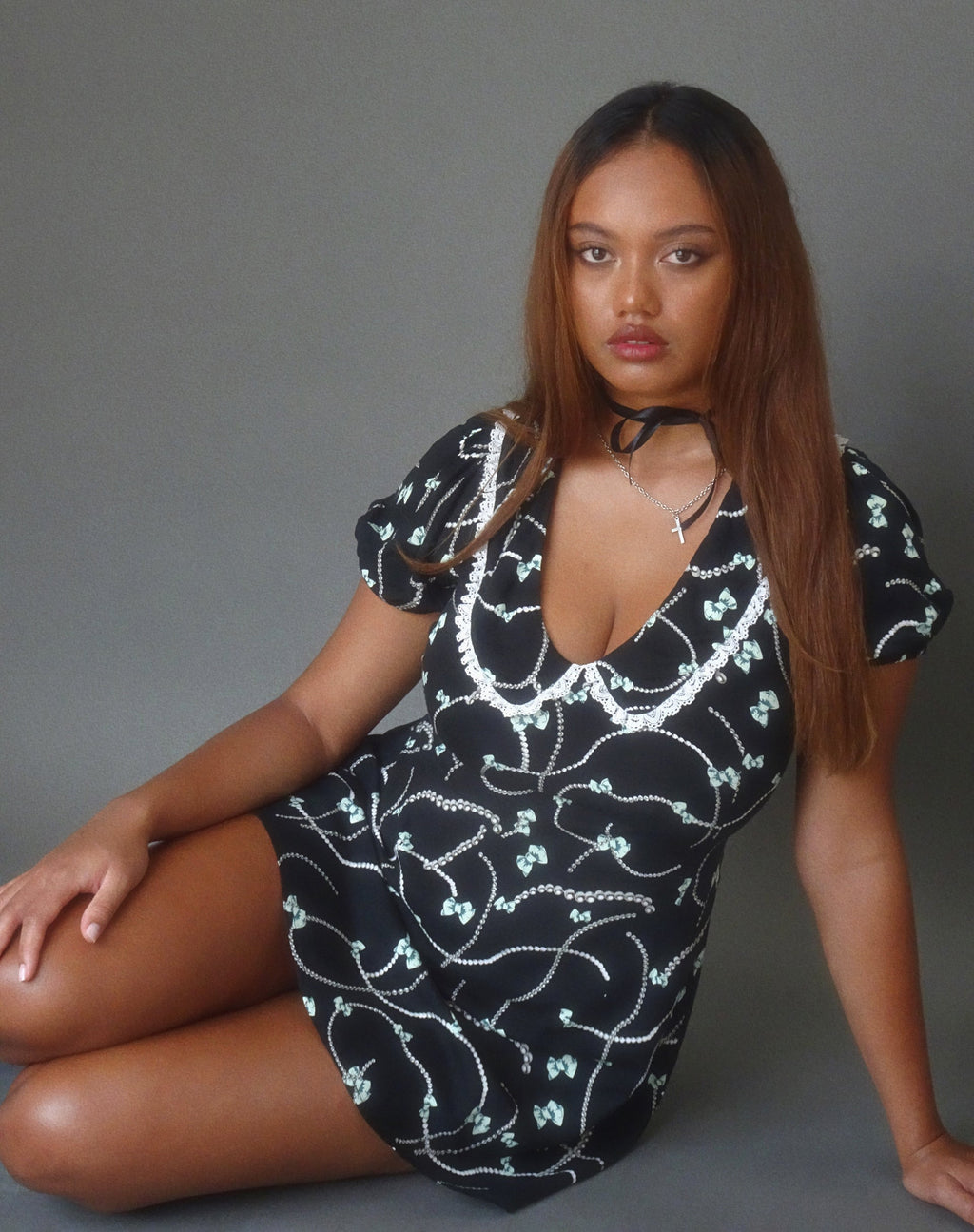 Minivestido Sulani en negro con estampado de perlas y lazos