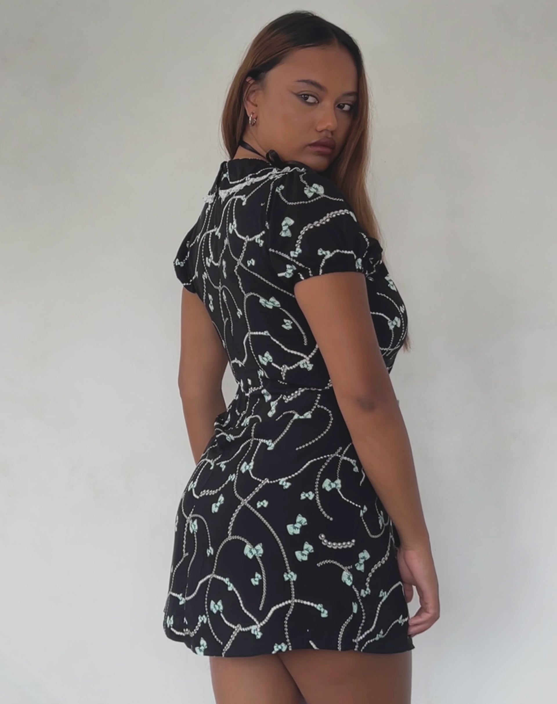Imagen de Sulani Minivestido negro con estampado de perlas y lazos