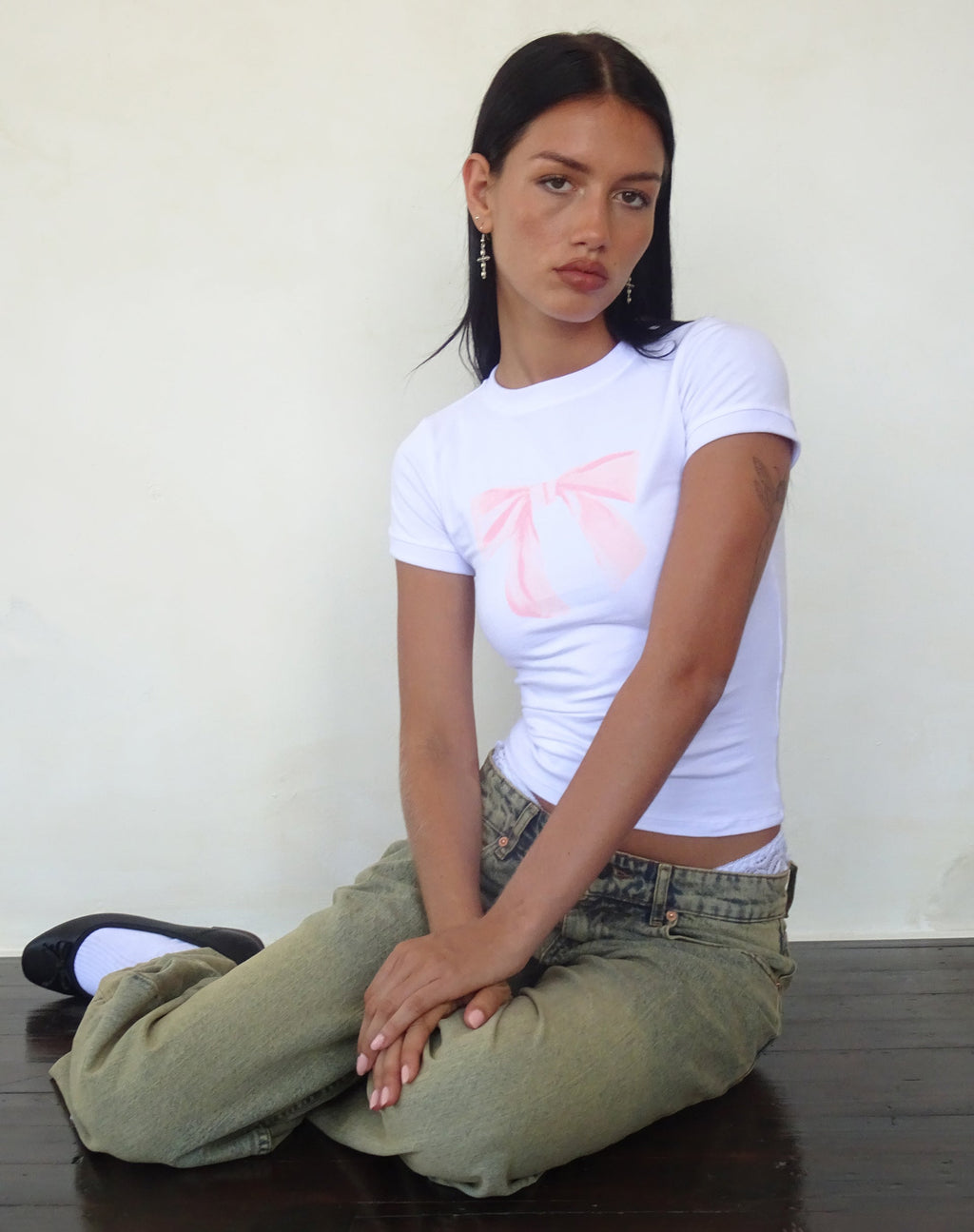 Sutin Baby Tee en blanco con estampado de lazo rosa